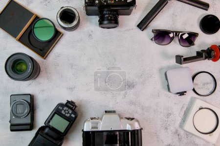 Une disposition méticuleusement organisée de l'équipement de la caméra, mettant en valeur un appareil photo reflex numérique, divers objectifs, filtres et accessoires essentiels