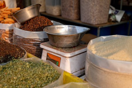 A quaint spice shop, its shelves laden with vibrant spices, centers around an old-fashioned weigh machine.