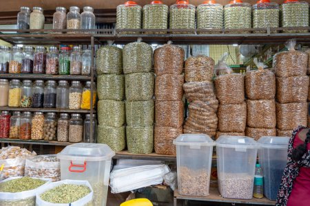Vibrant market scene featuring neatly arranged grains, spices, and legumes. Shoppers explore the rich culinary offerings