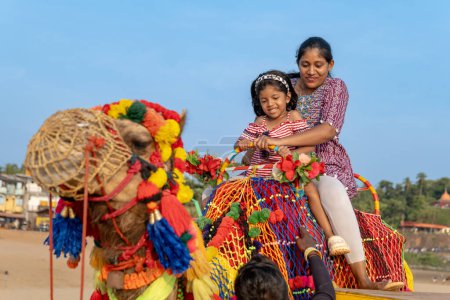A colorful camel ride by the beach brings mother and daughter closer, sharing laughter and memories.