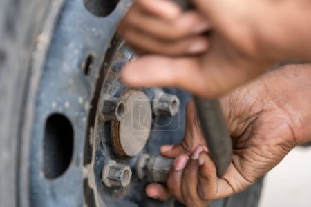 Close-up view of a skilled mechanic deftly removing a car tyre using specialized tools and precision.