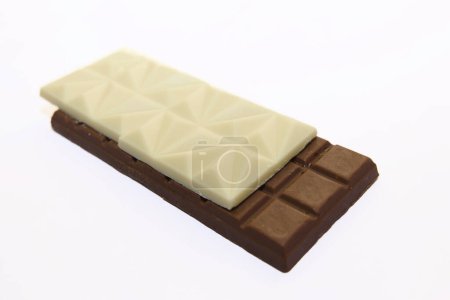 A tasteful blend of white and milk chocolate bars, meticulously stacked against a pristine backdrop