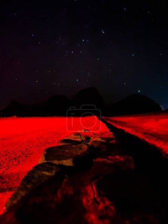 Photo for Starry night sky over the monument valley. Red light on a road under the night stars - Royalty Free Image