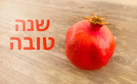 Photo for Pomegranate rimon photographed close up, with a New Year's greeting in Hebrew. for the celebration of Rosh Hashanah for the new year - Royalty Free Image