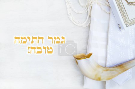Photo for Translation title: May you be signed and sealed in the book of life. in Hebrew. A shofar is placed on a tallit and siddur book on a white background. greeting card and Yom Kippur Rosh Hashanah - Royalty Free Image