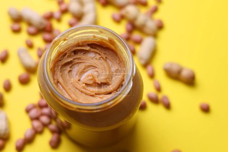 Téléchargez les photos : Beurre d'arachide sur un fond coloré. Photo de haute qualité - en image libre de droit