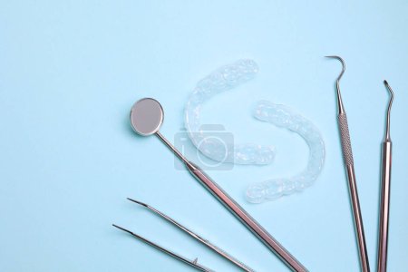 Téléchargez les photos : Aligneurs et outils en plastique transparent pour dentistes sur un fond coloré. Photo de haute qualité - en image libre de droit