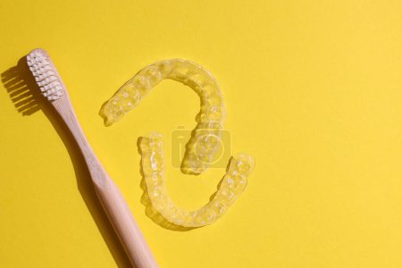 Téléchargez les photos : Aligneurs dentaires en plastique transparent sur un fond coloré. Photo de haute qualité - en image libre de droit