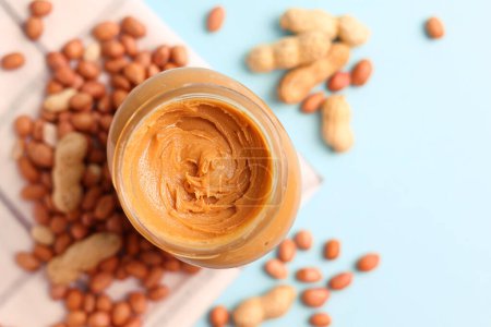 Photo for Peanut butter and raw peanuts on a colored background. High quality photo - Royalty Free Image