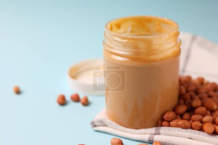Photo for Peanut butter and raw peanuts on a colored background. High quality photo - Royalty Free Image
