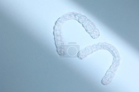 Téléchargez les photos : Aligneurs dentaires en plastique transparent sur un fond coloré. Photo de haute qualité - en image libre de droit