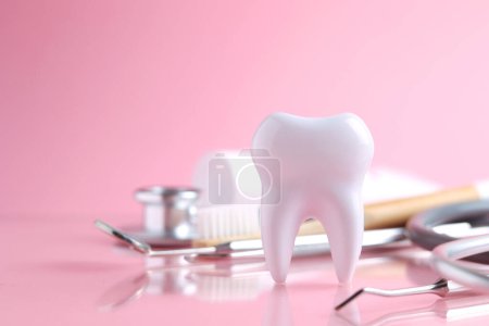 Foto de Concepto odontológico. Modelo de un diente e instrumentos dentales sobre un fondo de color con espacio para el texto. .. Foto de alta calidad - Imagen libre de derechos