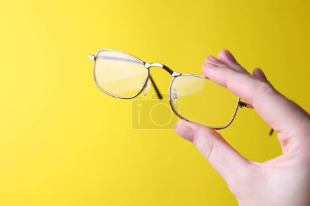 Photo for Glasses for vision correction in the hand on a colored background with space for text. High quality photo - Royalty Free Image