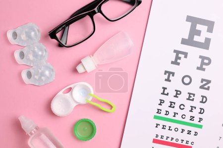 Photo for Vision test table, glasses and contact lenses on a colored background. High quality photo - Royalty Free Image
