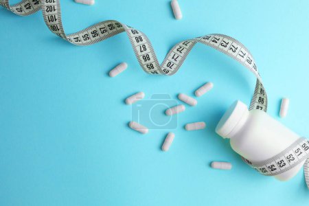 Photo for Centimeter tape and pills on a colored background with space for text. concept of losing weight, diet, fat burning, healthy eating. minimalism. . High quality photo - Royalty Free Image