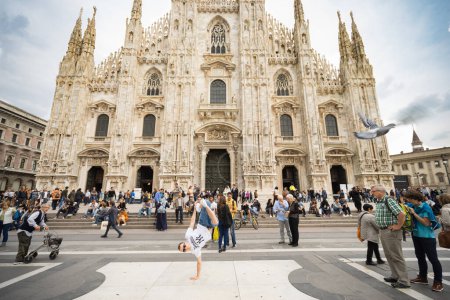 Photo for MILAN, ITALY -  OCTOBER 2015. Bboy break dancer performing freeze in front of peopple and Duomo Cathedral - Royalty Free Image