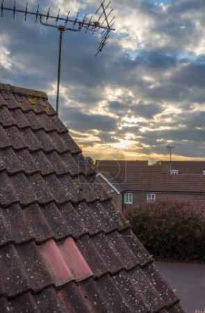 Photo for TV antenna on a roof of a building viewed at sunset - Royalty Free Image