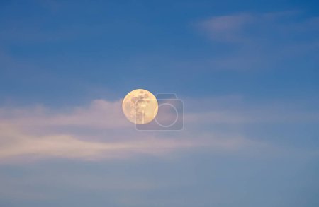 Photo for Moon at dawn with clouds pasing by - Royalty Free Image