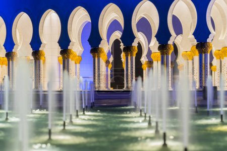 Téléchargez les photos : Galerie de la Grande Mosquée la nuit à Abu Dhabi avec la fontaine d'eau - en image libre de droit