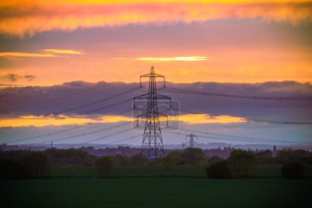Photo for Electricity Pylon - UK standard overhead power line transmission tower at sunset - Royalty Free Image