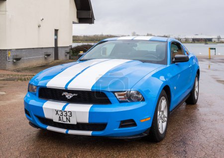 Photo for MILTON KEYNES, UK - 14 FEBRUARY 2017: Ford Mustang tuning sport-car colored in blue color with white stripes. Editorial photo - Royalty Free Image