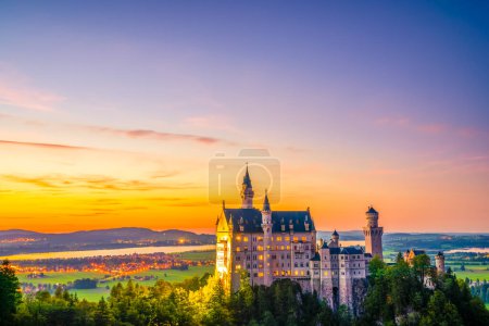 Téléchargez les photos : Belle vue sur le coucher du soleil du célèbre château de Neuschwanstein, palais néoroman du XIXe siècle construit pour le roi Ludwig II sur une falaise accidentée près de Fussen, dans le sud-ouest de la Bavière, en Allemagne - en image libre de droit