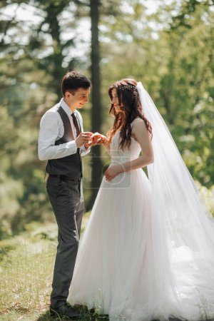 Photo for Stylish young brides, happy on their day, enjoy each other. The groom puts on the wedding ring of the bride. Portrait. Spring wedding. Natural makeup - Royalty Free Image