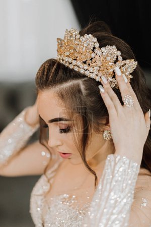 Eine junge Prinzessin in einem teuren Luxuskleid mit vergoldetem Diadem auf dem Kopf steht. Stilvolle Mode