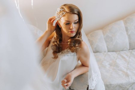 Foto de Novia rubia con hermoso cabello y maquillaje, preparándose para la ceremonia de la boda. Fotografía horizontal. - Imagen libre de derechos
