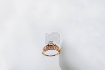 Photo for Combined gold wedding ring decorated with diamonds. Solitaire diamond engagement ring in yellow gold with a four prong setting - Royalty Free Image