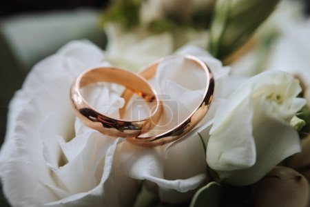 Photo for Wedding rings lie on a beautiful bouquet as bridal accessories - Royalty Free Image