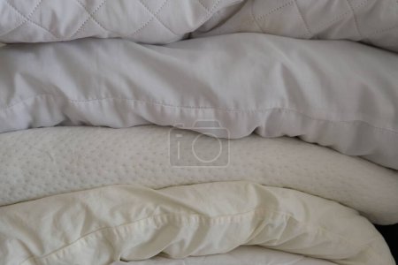Photo for Stacked white pillows are on a furniture as a background photo. Many pillows are in a row. - Royalty Free Image