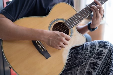 Foto de Cerrado mano tocando la guitarra, Hombre tocando la guitarra acústica de caoba, guitarra con la mano tocando - Imagen libre de derechos