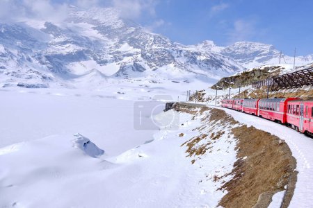 Foto de Paso de montaña de Bernina. El famoso tren rojo está cruzando el lago blanco. Increíble paisaje de la tierra de Suiza. Destino famoso y atracción turística. Lo mejor de Suiza - Imagen libre de derechos