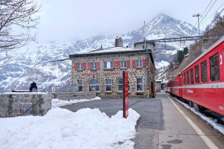 Foto de Canton Graubunden, Suiza: Paisaje en Alp Grum estación de tren (Bernina express) durante la temporada de invierno, alpes suizos en el fondo - Imagen libre de derechos