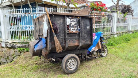 Téléchargez les photos : Moteur indonésien tricycle poubelle ou camion à benne en face du complexe de logements. - en image libre de droit