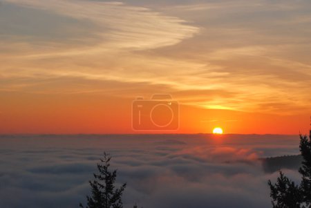 Foto de Salida del sol naranja y dorada sobre un valle lleno de niebla en el extremo sur de la isla de Vancouver, BC - Imagen libre de derechos