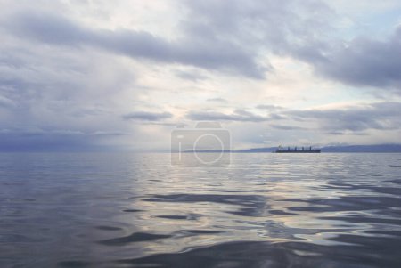 Photo for A container ship navigates through the Juan De Fuca Strait on a gloomy and calm morning - Royalty Free Image