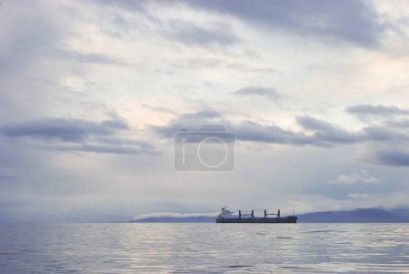 Foto de Un buque portacontenedores navega por el estrecho de Juan De Fuca en una mañana sombría y tranquila - Imagen libre de derechos
