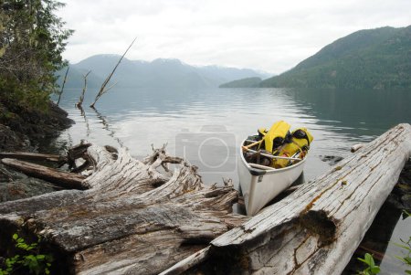 Foto de Una canoa de expedición se encuentra a la orilla de un tranquilo Great Central Lake, Vancouver Island, BC, Canadá - Imagen libre de derechos