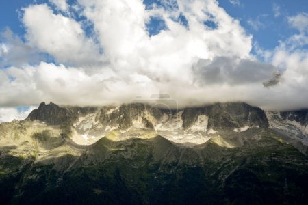 Paisaje montañoso de increíble vista sobre valle a montaña nevada cubierta de nubes bajas