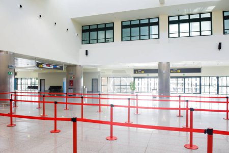 Airport departure and arrivals interior of baggage check in building with no people in the queue