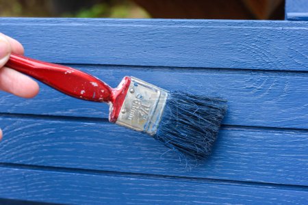 Peinture au pinceau peinture bleue sur une surface en bois