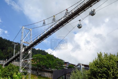 Cable cars and a foot bridge allow cyclists and people to reach the mountain top at a ski resort