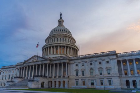 Téléchargez les photos : Le Capitole des États-Unis à l'heure bleue avec le drapeau américain - en image libre de droit