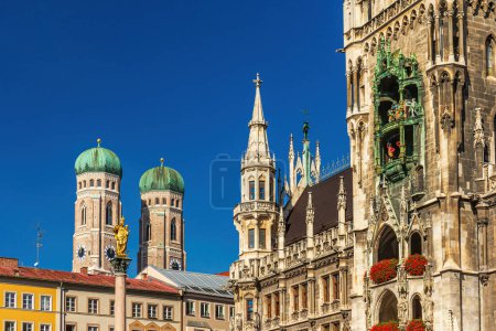 Schönes Wahrzeichen Münchens, die Frauenkirche mit dem Neuen Rathaus und der goldenen Statue der Maria mit Kind