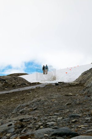 Foto de Vista trasera de dos excursionistas caminando en Harding Icefield en las montañas de Alaska, EE.UU. - Imagen libre de derechos