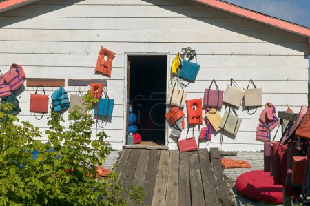 Photo for Exterior of a wooden clubhouse or store displaying life jackets and boating accessories on its wall - Royalty Free Image
