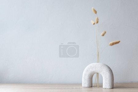 Habitación minimalista, rama con flor de maceta sobre fondo de pared vacío