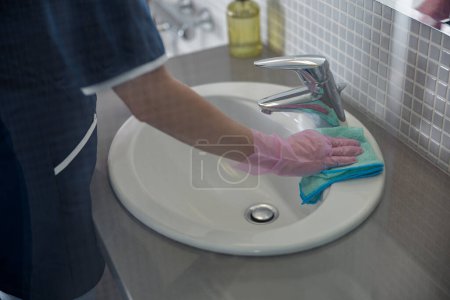 Foto de Primer plano de las manos de la camarera de limpieza grifo en el baño. Foto de alta calidad - Imagen libre de derechos